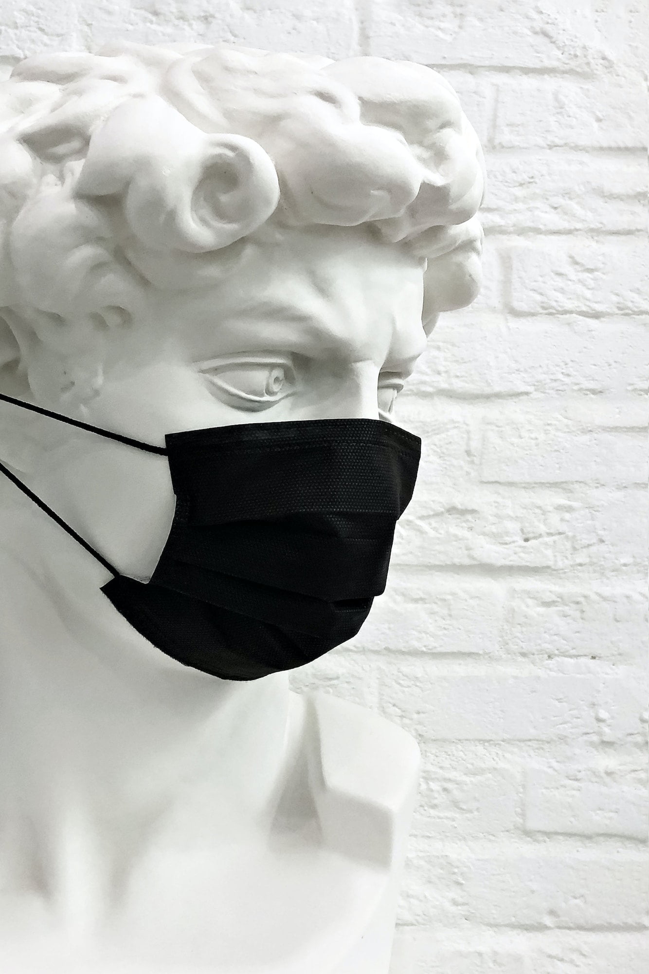 a statue with a medical protective mask concept of the coronavirus pandemic